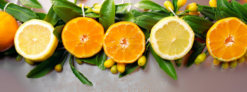 Photo of fresh oranges and lemons with a leafy background